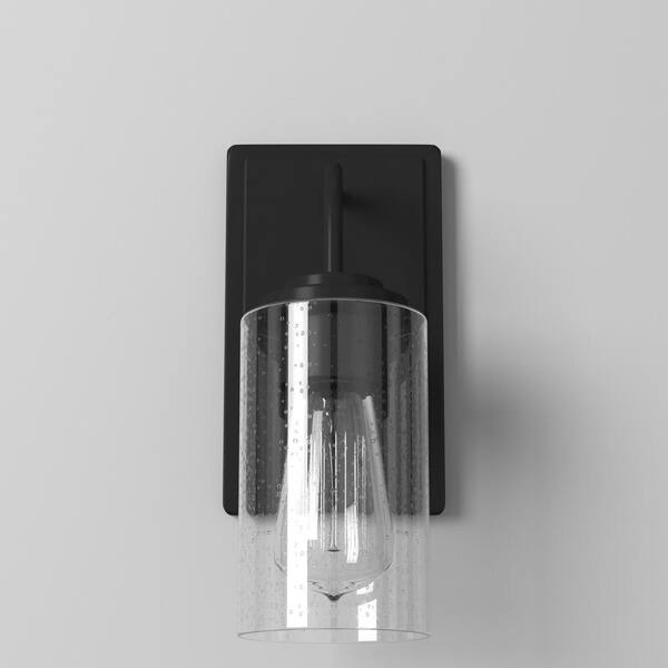 Designers Fountain - Logan 4.5 in. 1-Light Matte Black Transitional Wall Sconce with Clear Seedy Glass Shade