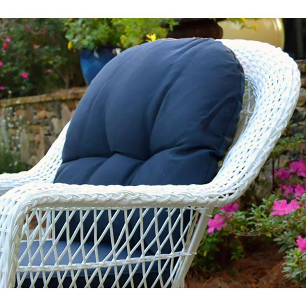 White wicker armchair with dark blue cushion outdoors.