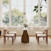Four white lambswool dining chairs with walnut legs arranged around a white table.
