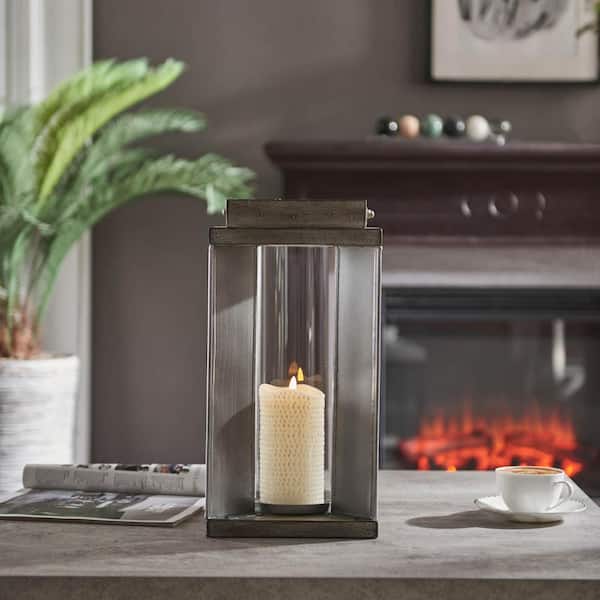 collapsible camping candle lantern burning in darkness on a rustic