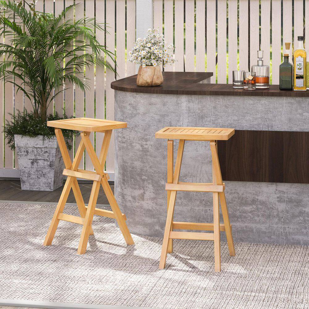 Two teak wood bar stools positioned near an outdoor bar counter.