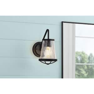 Georgina 5.75 in. 1-Light Matte Black Industrial Rustic Wall Sconce with Clear Seeded Glass Shade and Cage Accent