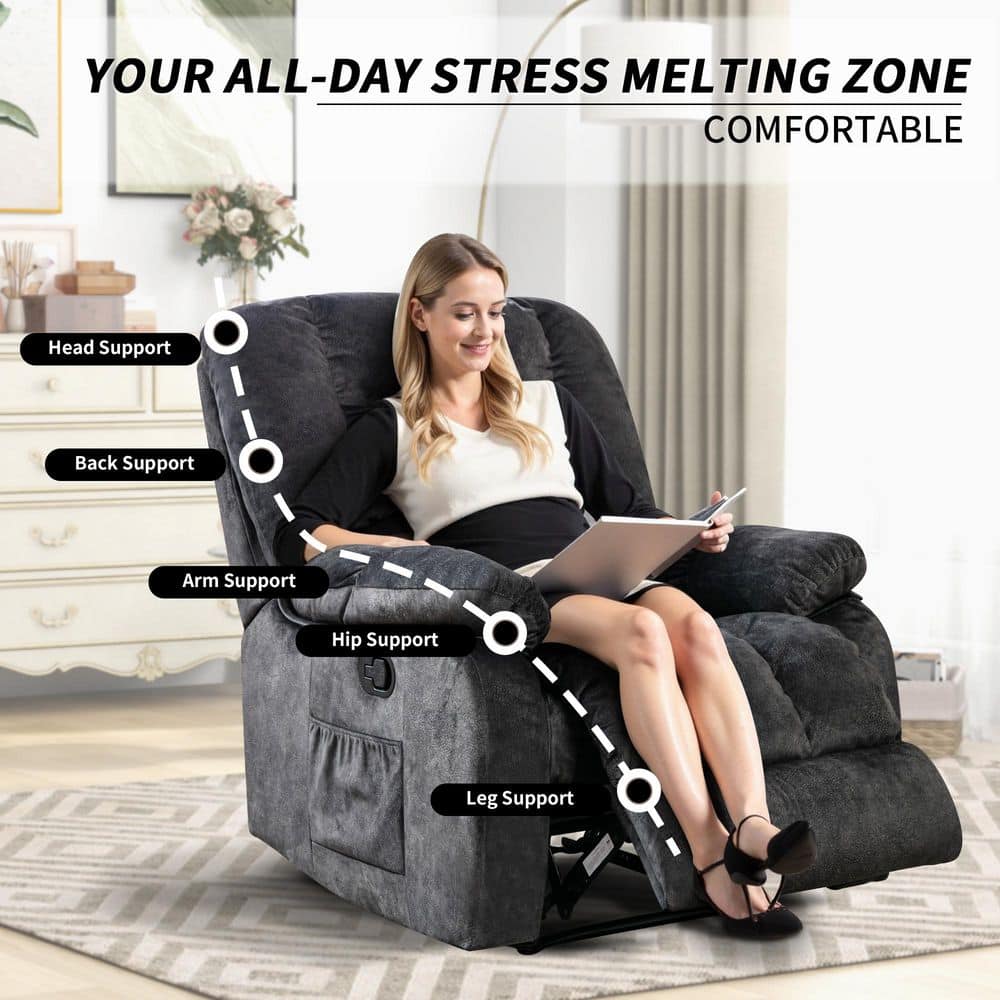 A woman sitting in a blue-gray recliner chair using a laptop.