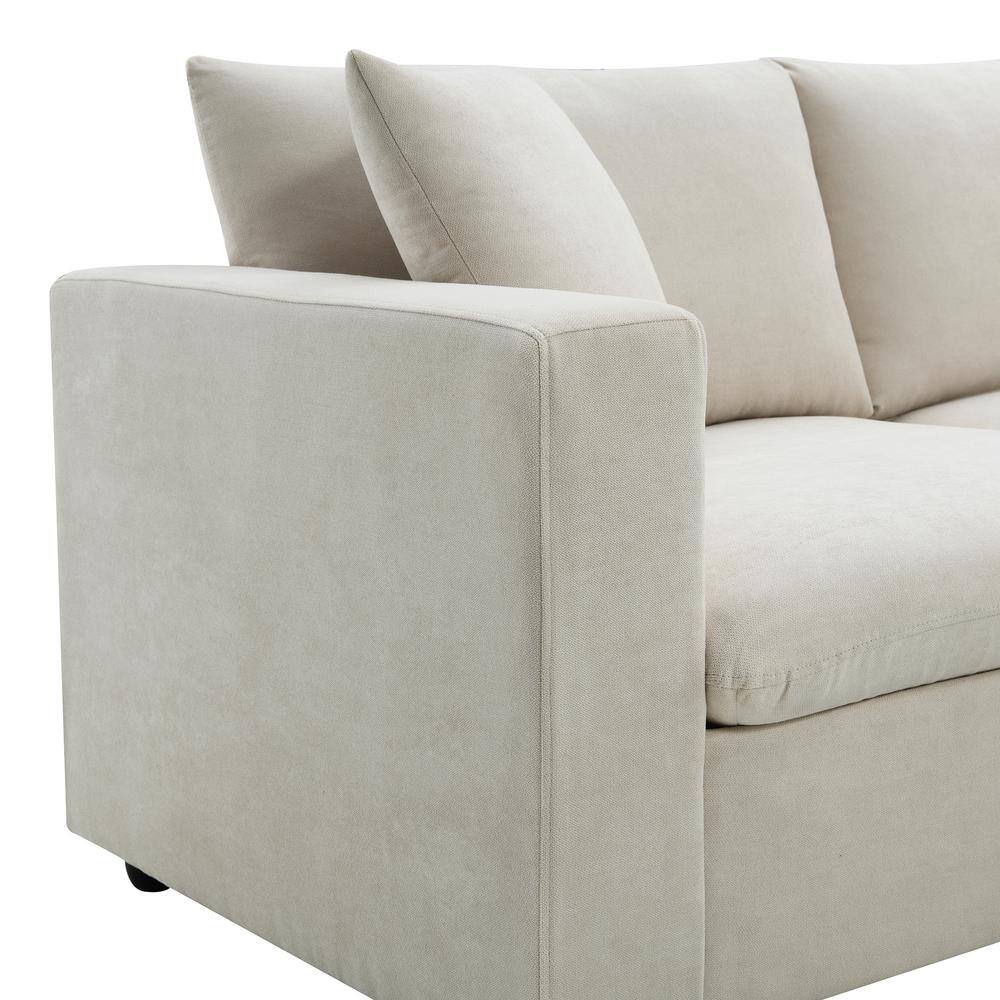 Close-up of the corner and armrest of a beige sectional sofa.