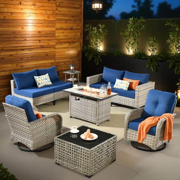 XIZZI Enchanted 9 Pieces Wicker Outdoor Patio Rectangular Fire Pit Set and Swivel Rocking Chairs with Navy Blue Cushions