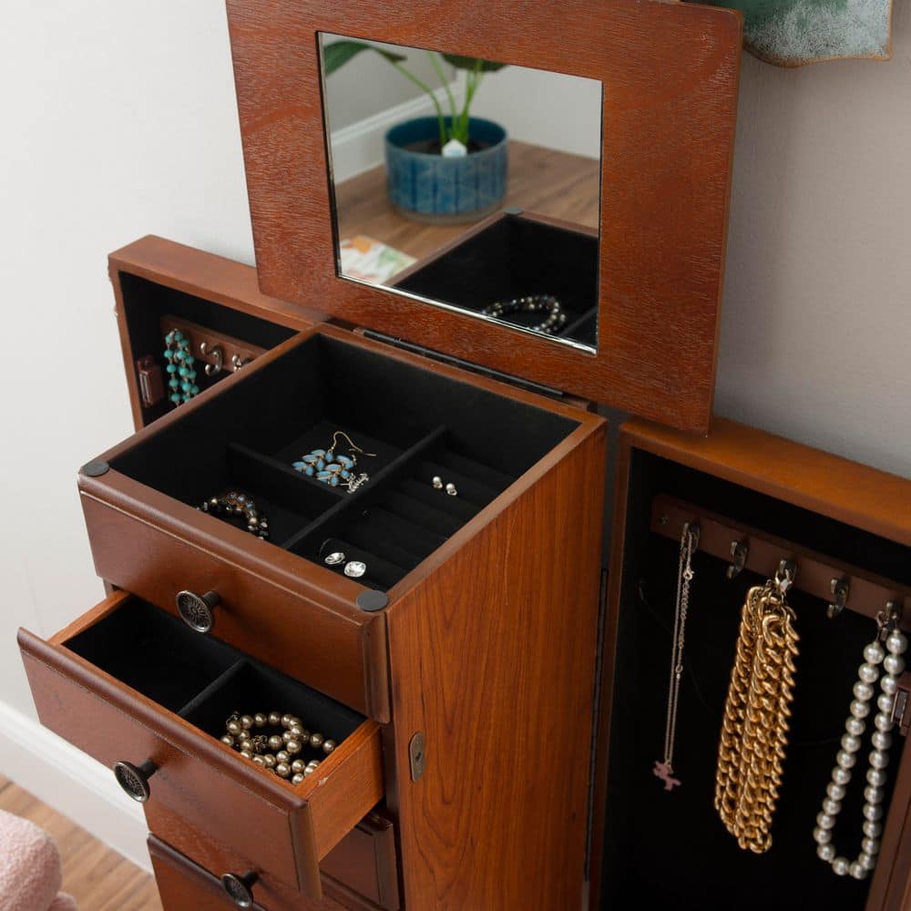 Close-up of open jewelry armoire drawers with jewelry