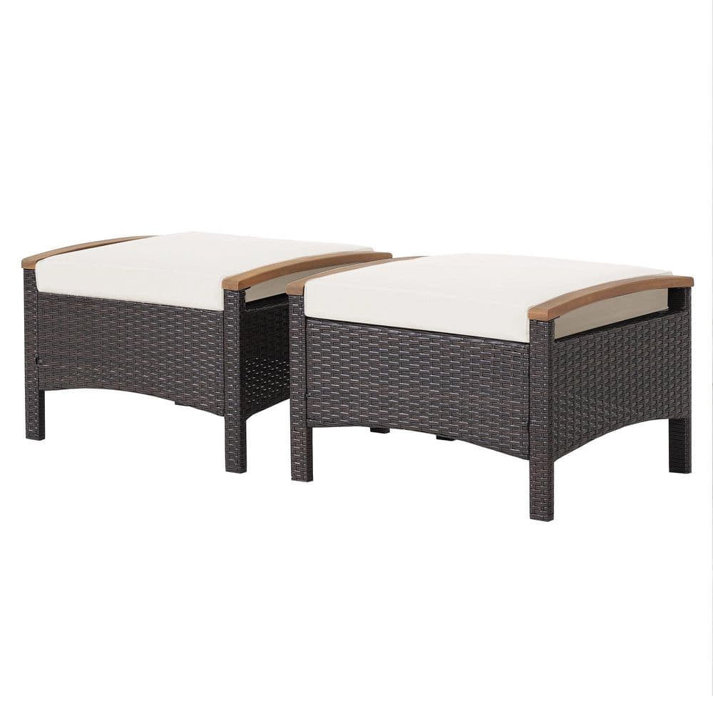 Two outdoor wicker ottomans with white cushions on a plain background.