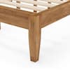 Close-up view of the corner and leg of the natural wood bed frame.