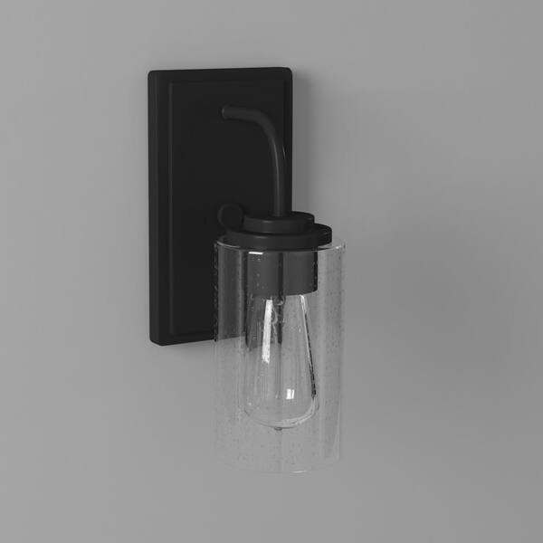 Designers Fountain - Logan 4.5 in. 1-Light Matte Black Transitional Wall Sconce with Clear Seedy Glass Shade