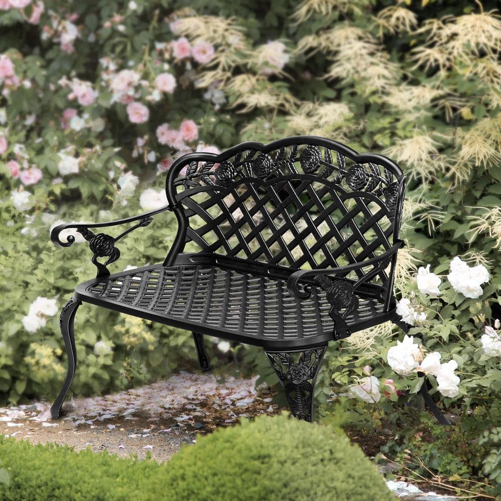 Black outdoor bench in a beautiful garden setting.