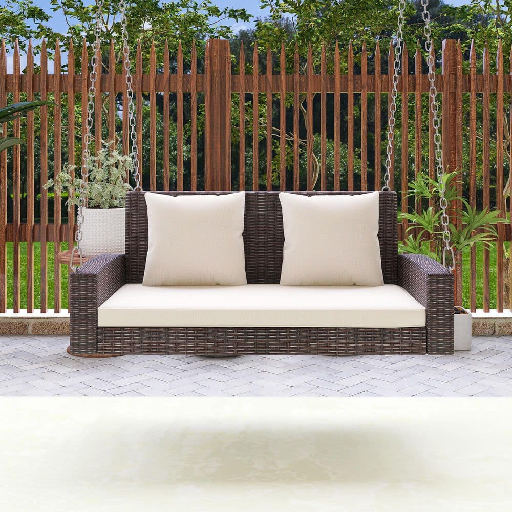 2-Person Outdoor Brown Wicker Patio Swing with Beige Cushions and Pillow