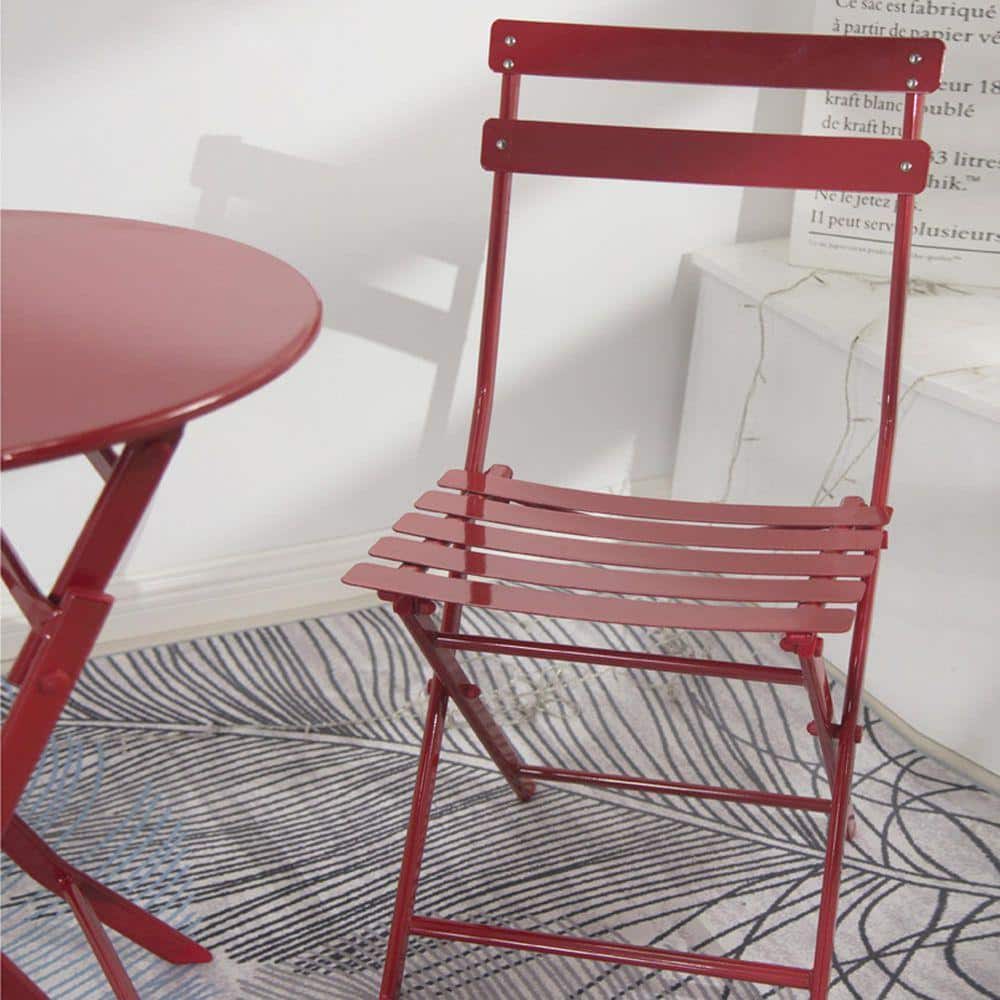 Close-up of a red metal folding chair seat and backrest.