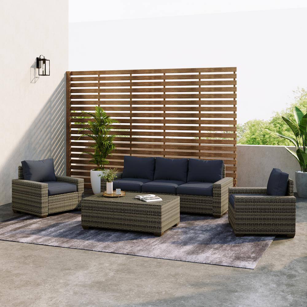 6-piece rattan outdoor sectional seating group with navy cushions and a glass table.