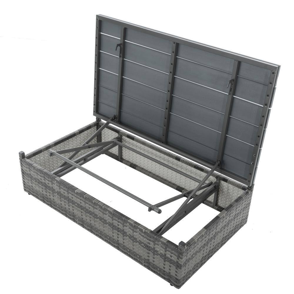 Gray wicker coffee table with the lift-top open to show internal storage.