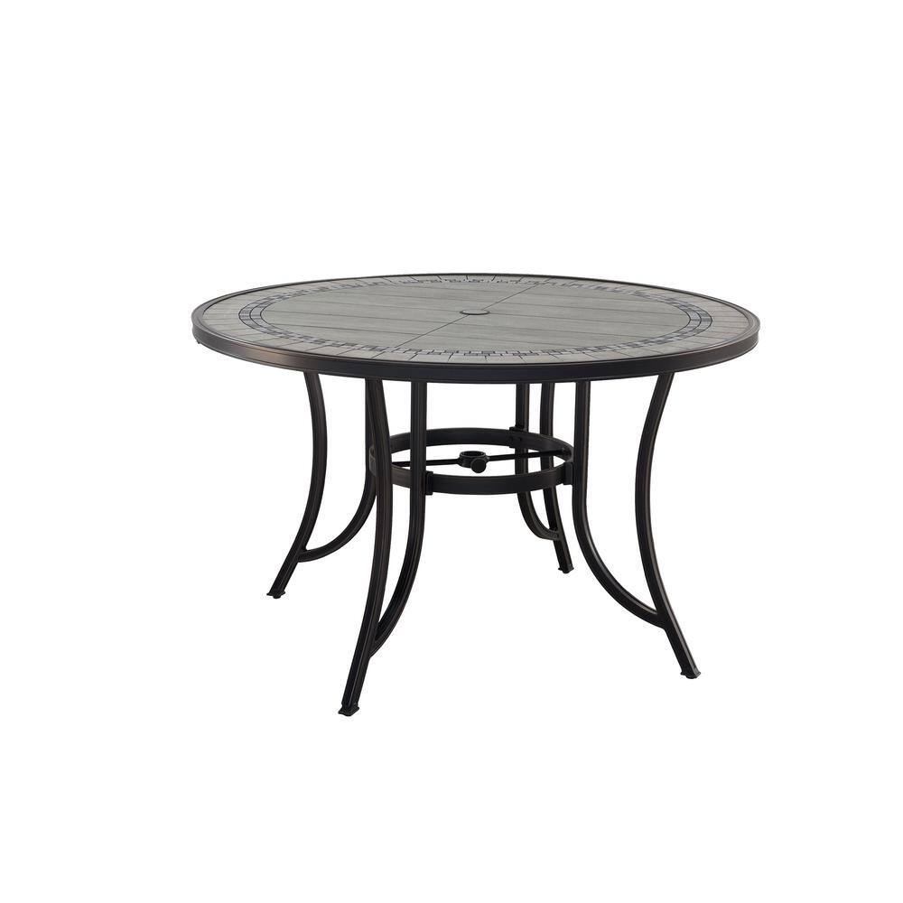 Round outdoor dining table with black metal legs and gray tabletop.