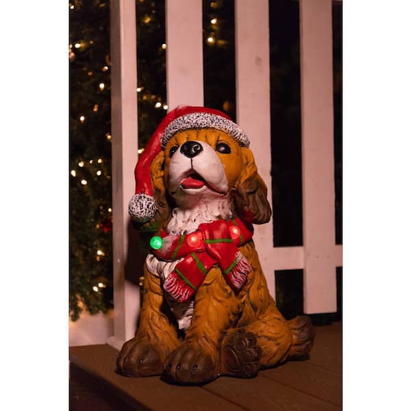 Alpine Corporation 21 in. Dog Wearing Santa Hat and Red Scarf Decor with 3 LED Lights