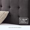 Close-up view of the charcoal upholstered headboard texture and tufting.