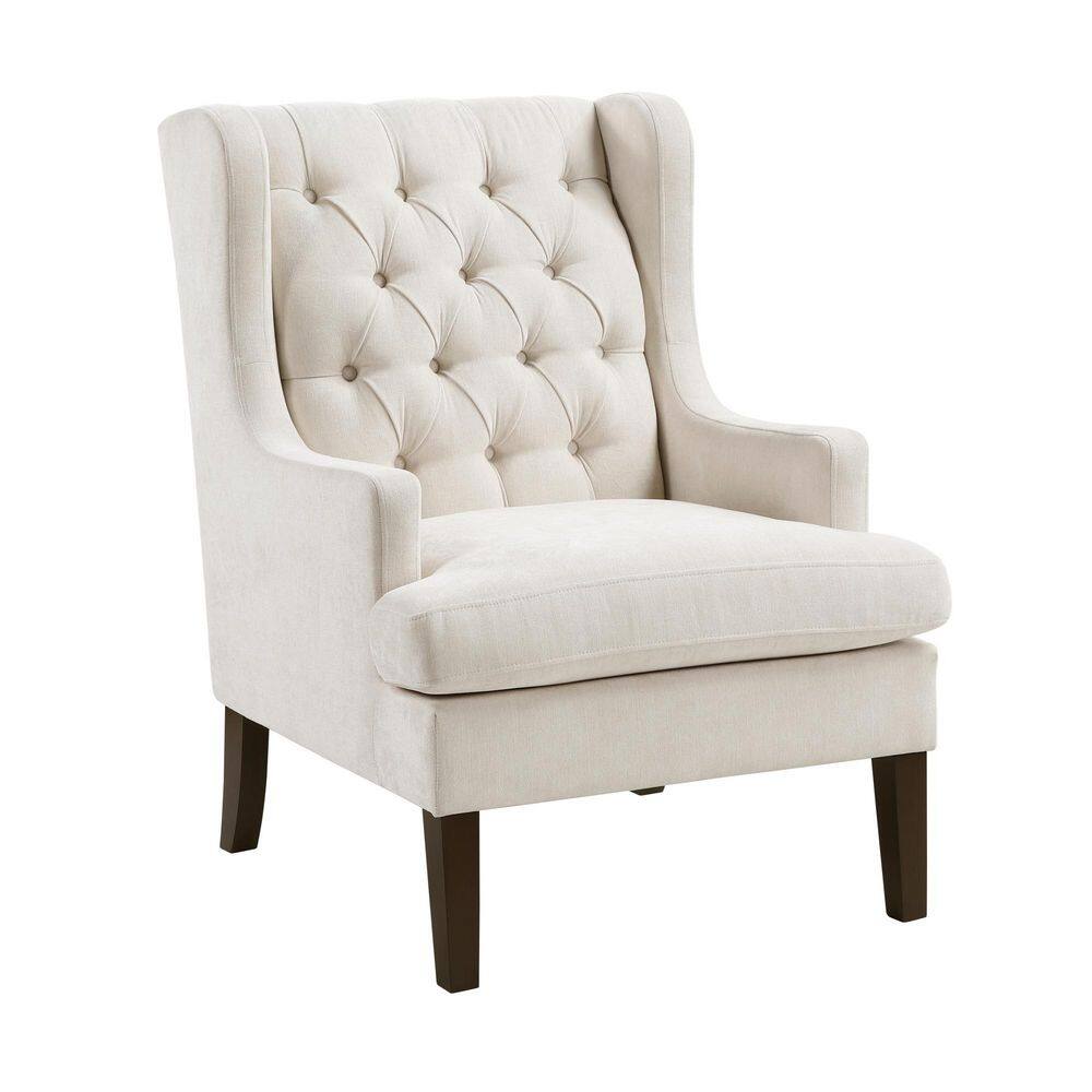 Front view of a beige tufted wingback armchair.