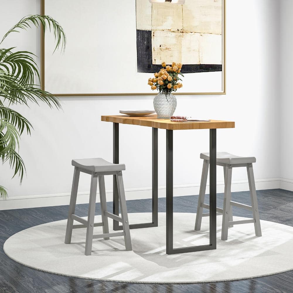 Two grey saddle stools at a high wooden table.