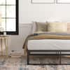 Close-up of black metal bed frame with mattress