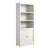 White particleboard bookcase standing against a white wall.