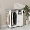 White accent cabinet with grey ironing top and hanging clothes, placed next to a potted plant.