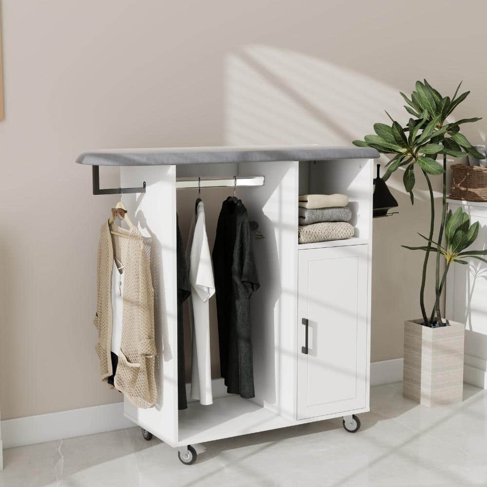 White accent cabinet with grey ironing top and hanging clothes, placed next to a potted plant.