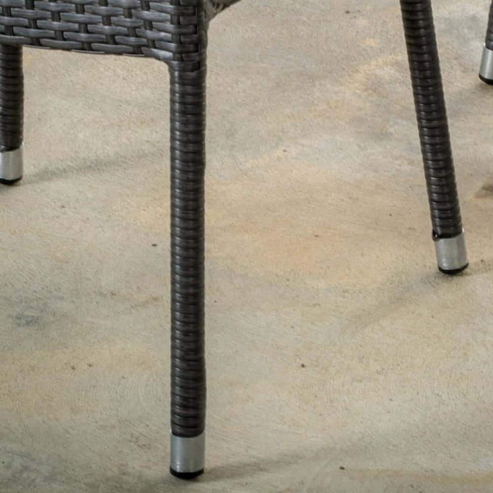 Close-up of the legs and feet of a gray wicker chair.