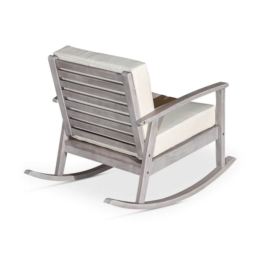 Weathered wood rocking chair with gray slats and off-white cushions.