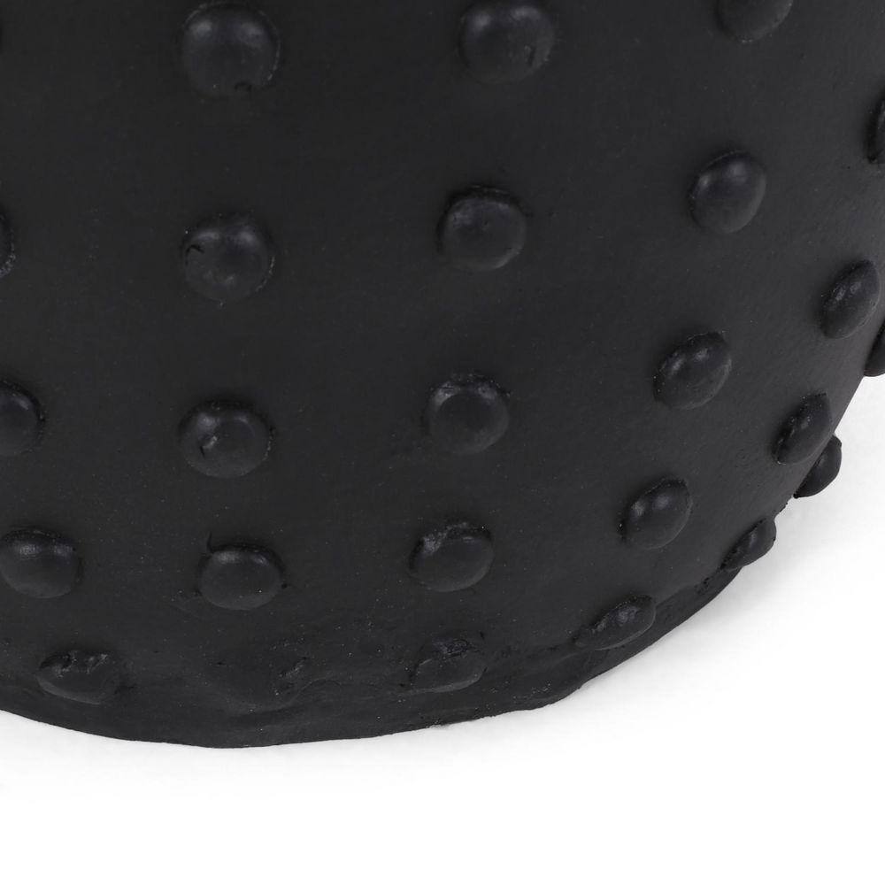Close-up of the studded texture on a matte black side table.
