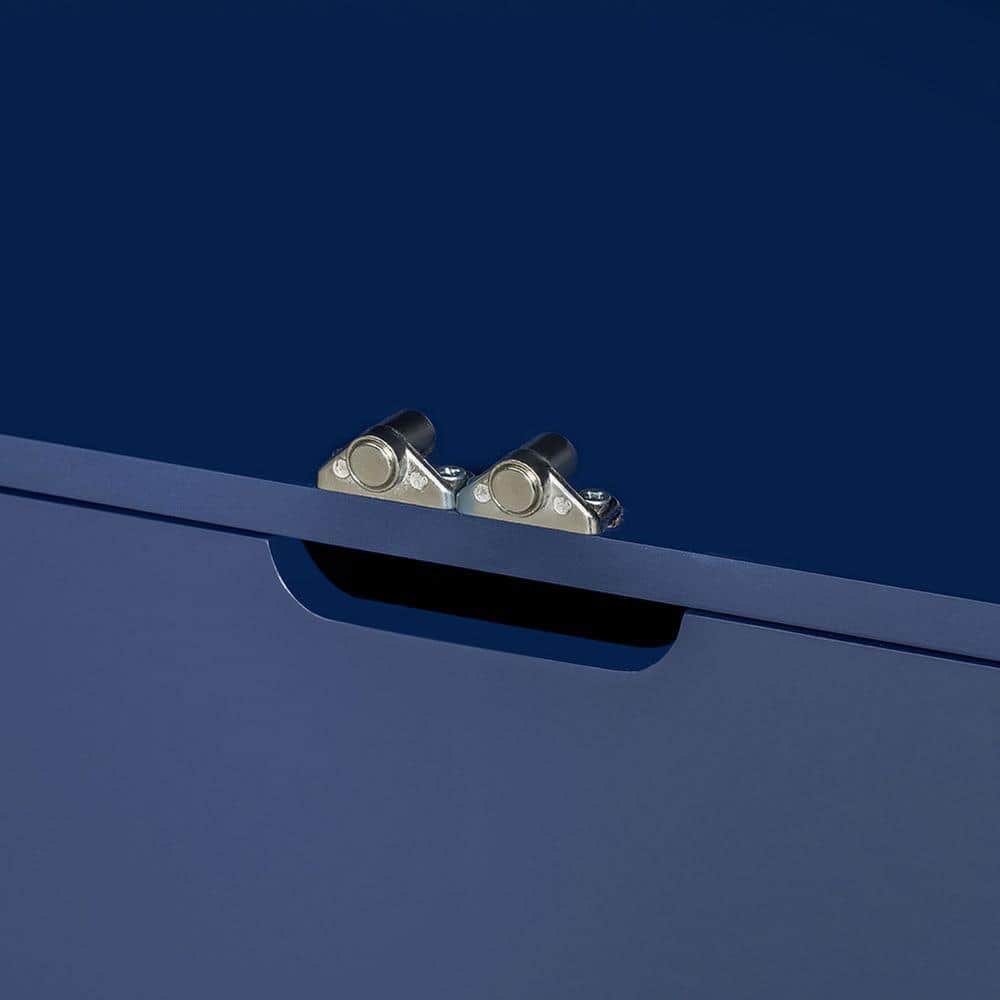 Close-up of silver metal hinges on the navy blue cabinet.