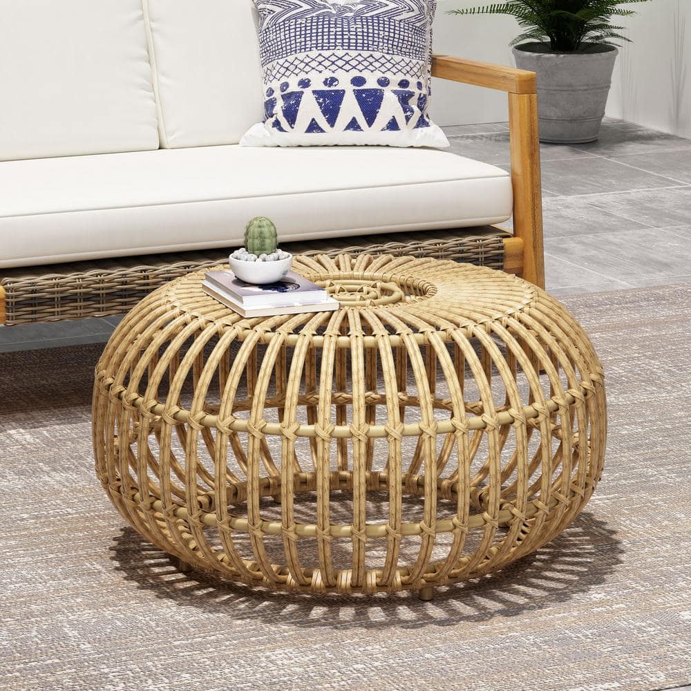 Wicker outdoor side table on a rug next to outdoor seating.