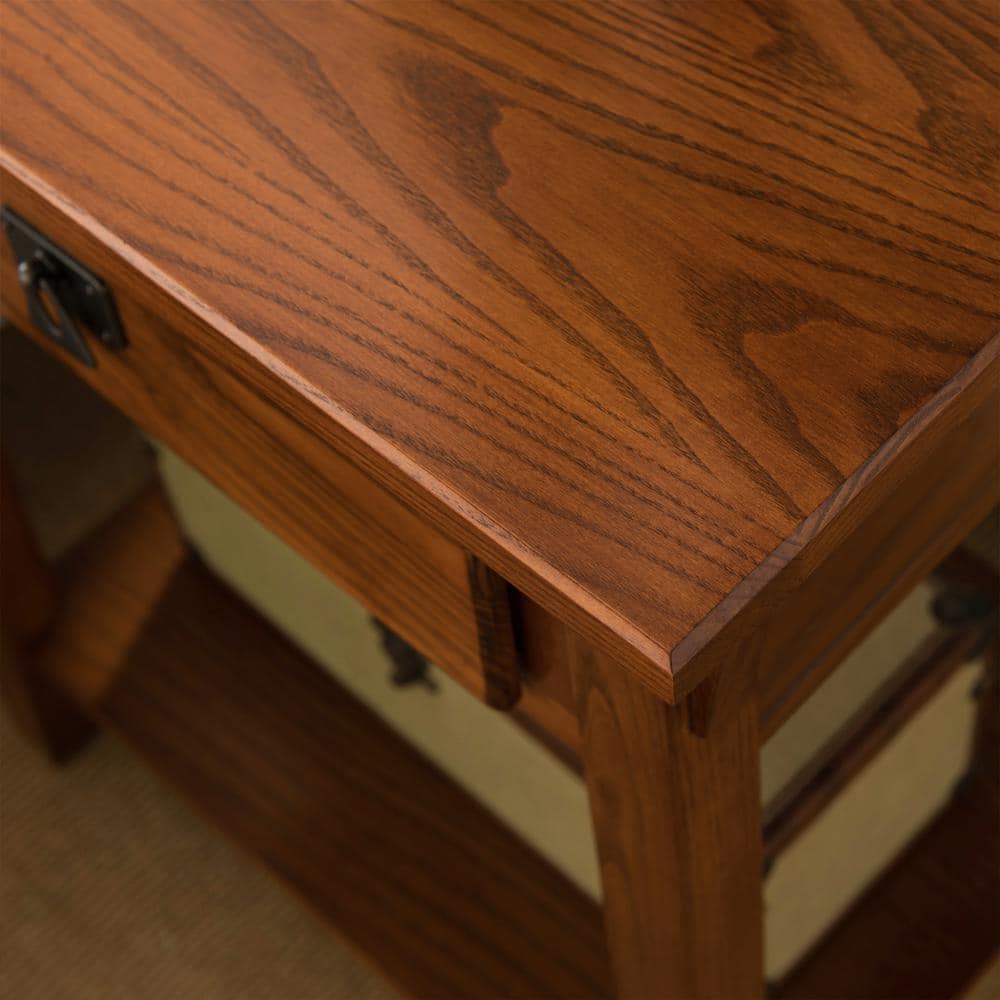 Close-up of the wood grain and drawer handle of a brown solid wood end table.