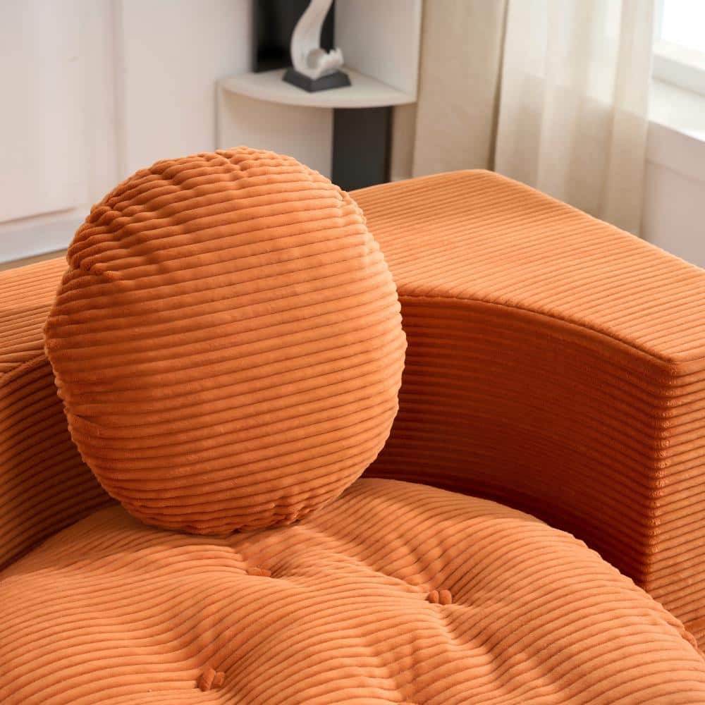 Close-up of a round orange corduroy pillow.