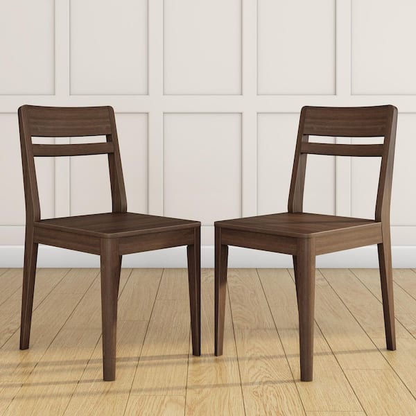 Two dark brown wood dining chairs standing side by side on a wooden floor.