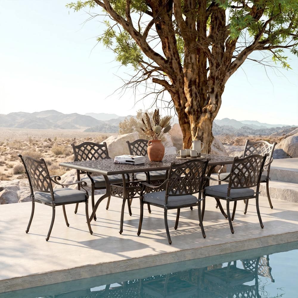 Outdoor dining set set up poolside on a wooden deck overlooking nature.