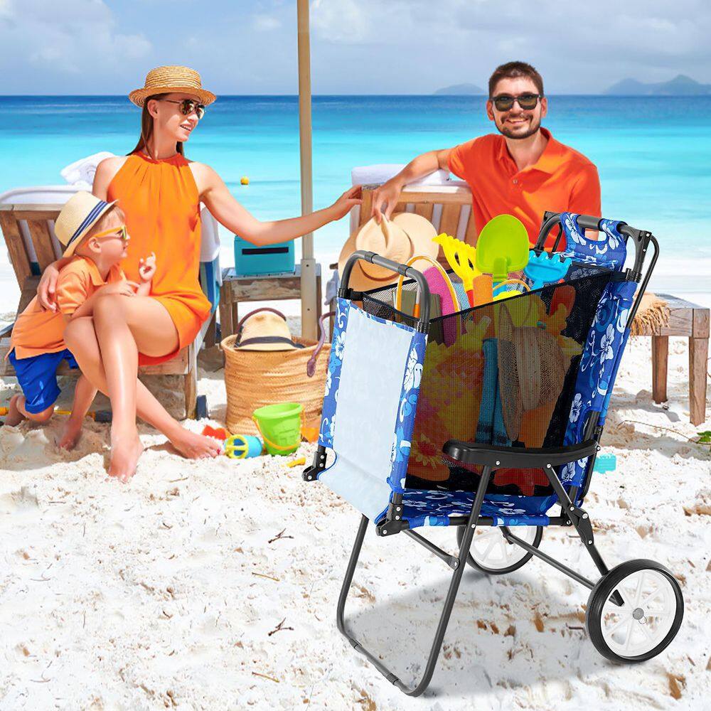 Blue floral beach chair converted into a cart filled with beach toys on a sandy beach.