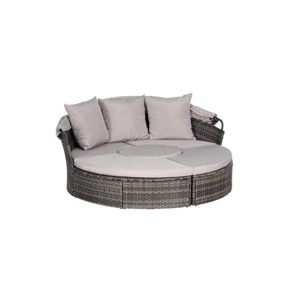 Round wicker outdoor day bed with light gray cushions, canopy removed.