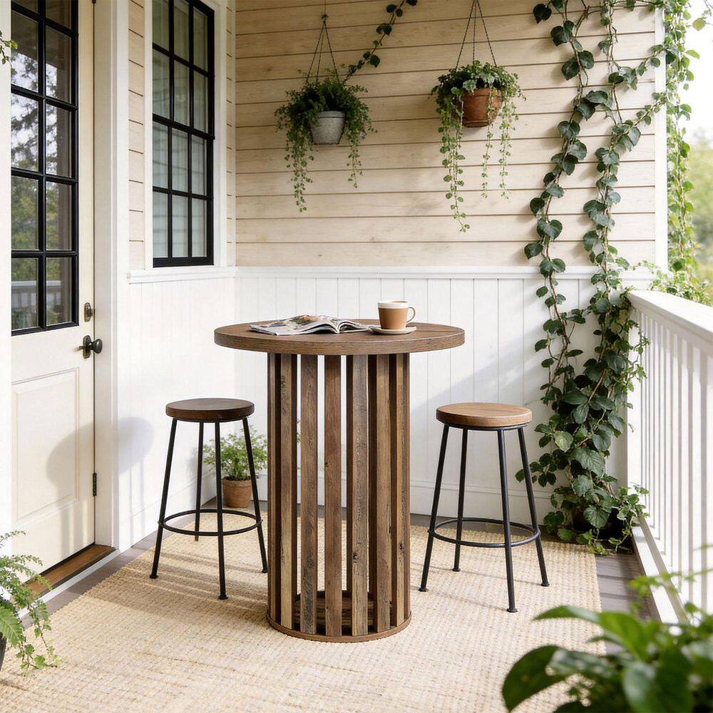 Round wooden bar table with stools in a bright setting with plants.