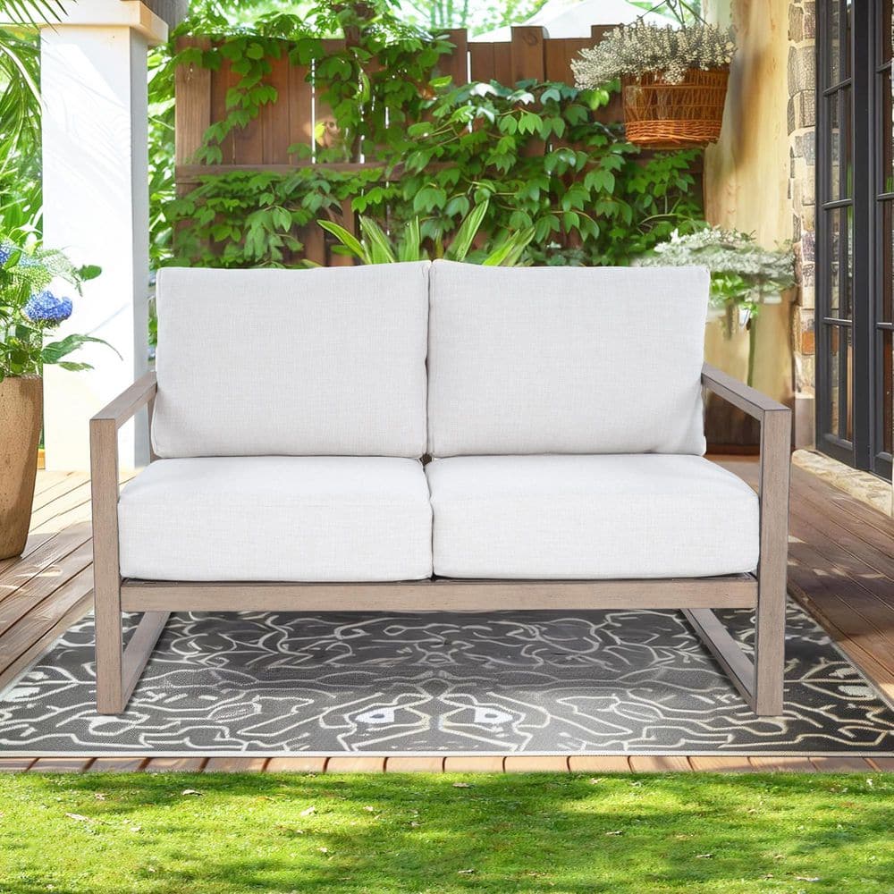 Front view of the Hamarto outdoor loveseat with warm white cushions.