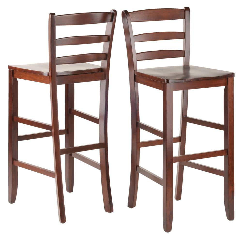 Two walnut ladder-back bar stools on a white background.