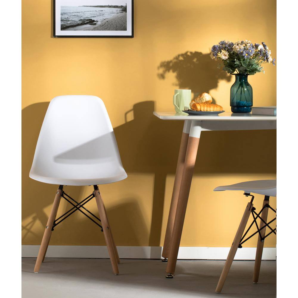 White shell dining chair positioned next to a white dining table.