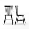 Two black spindle back dining chairs against a white background.