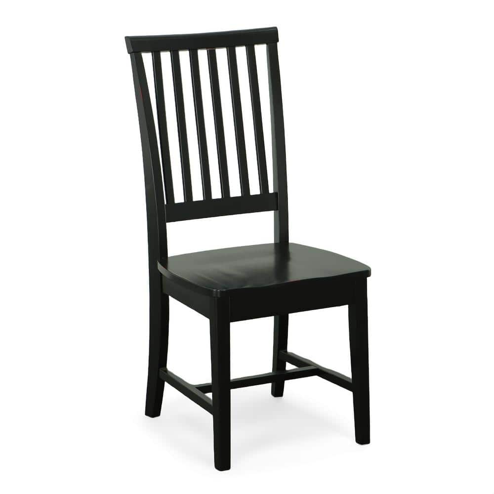 Antique black wood dining chair with a slatted back, shown from a three-quarter angle.