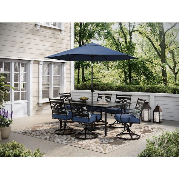 Hanover Montclair 7-Piece Steel Outdoor Dining Set with Navy Blue Cushions, 6 Swivel Rockers, 40 in. x 66 in. Table and Umbrella