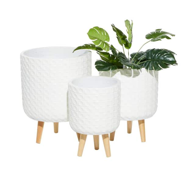 https://images.thdstatic.com/productImages/7903fa07-6c4b-462f-8680-00ec851578cf/svn/white-cosmoliving-by-cosmopolitan-plant-pots-46520-64_600.jpg