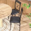 Dining set with a light wood table and black dining chairs in a bright room.