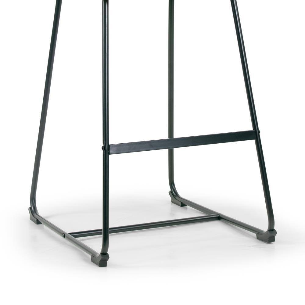 Close-up of the black metal frame and footrest of a bar stool.