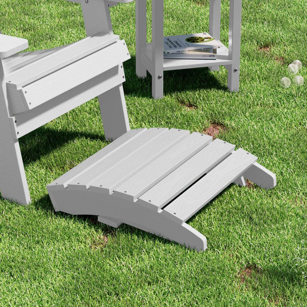 A white Adirondack chair and small side table set on a green lawn.