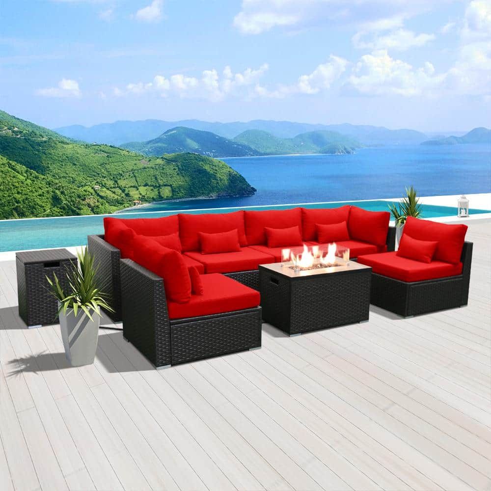 Perspective view of a black wicker patio set with red cushions and a central gas fire pit.